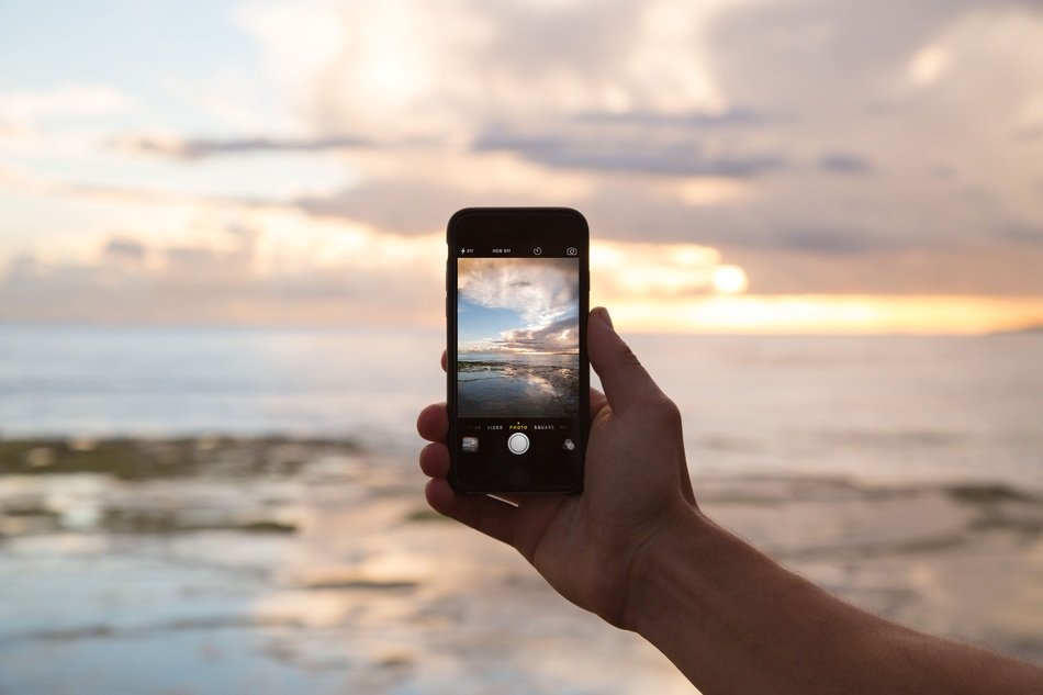 phone in hand against the sea