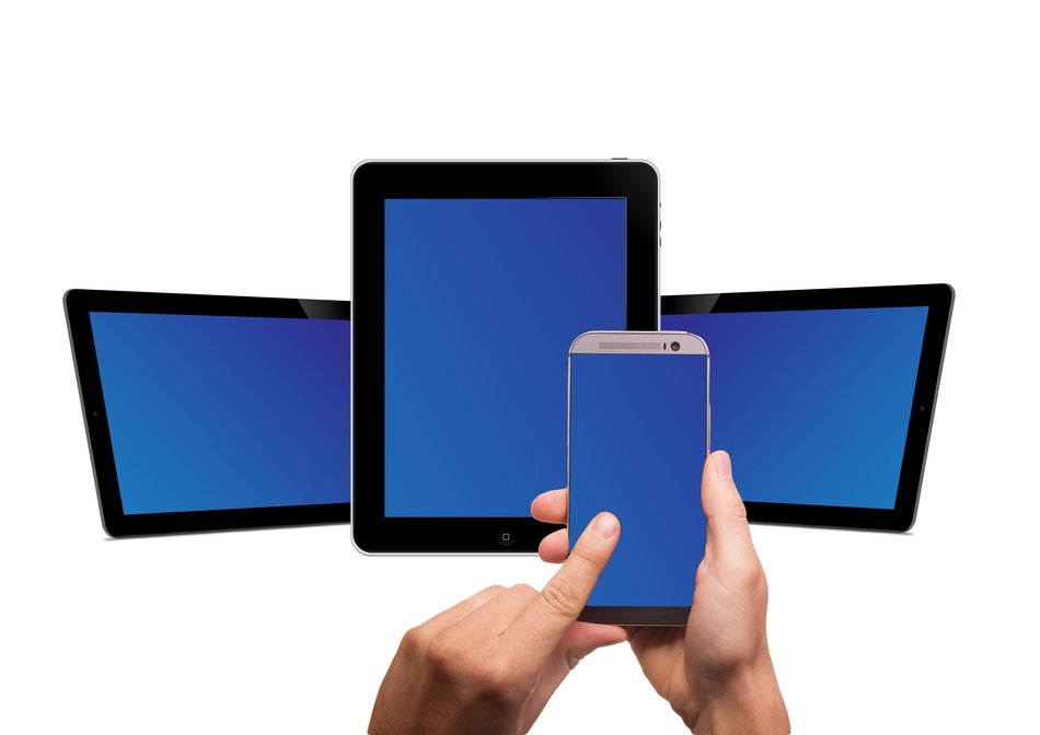 Mobile phone in hands on background of tablets