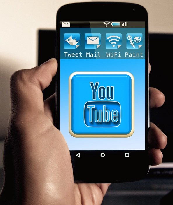 smartphone with youtube sign in manâs hand