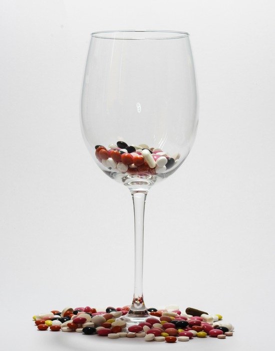 Multicolored tablets in a glass and around
