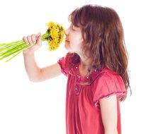 photo of a girl sniffing a bouquet of dandelions