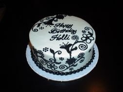 white cake with black drawings for a birthday