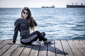 photo of a girl on a wooden floor by the sea