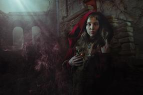 witch in a red cape in a mystical gothic landscape