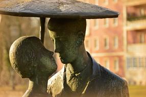 bronze sculpture of lovers under umbrella