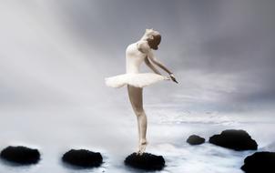 photo of graceful ballerina on a cobblestone on the ocean