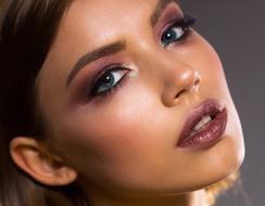 Portrait of the woman with colorful make-up, at gray background