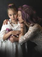 mom and daughter with beautiful hairstyles in white lace dresses