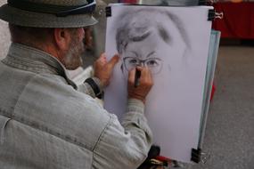 Painter is drawing black and white portrait on a street