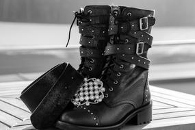 Black and white photo of the beautiful, black shoes and belt, on the wooden surface