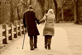 monochrome photo of a walking elderly couple