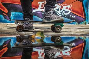 male legs and skateboard at bright graffiti