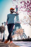 photo of a fashionable young man against the backdrop of the Eiffel Tower
