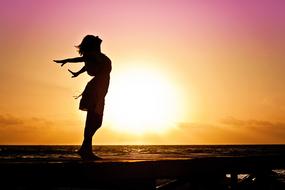 Woman stands on beach at sea, Happiness