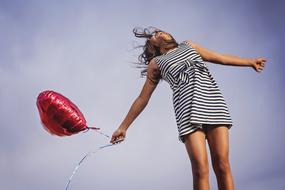 girl in a striped dress with a balloon