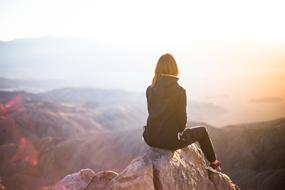 girl enjoys freedom on top of a mountain