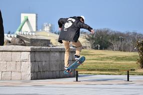 man jumps with Skateboard in park