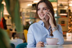 cheerful Woman talking on phone in Cafe