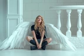 Blonde woman with beautiful, white angel wings, on the photoshoot