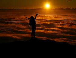 hiker enjoying sunset in mountains