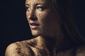 Portrait of the woman, in light and shadow, at black background