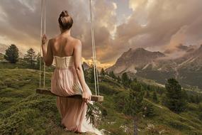 bride on a swing on a hill