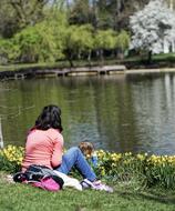 girl sitting on the shore near the lake