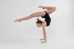 Gymnastics, young girl doing exercise on floor