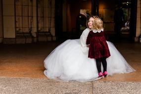 child girl kissing Bride in white Dress