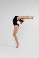 gymnast in a black leotard on a white background