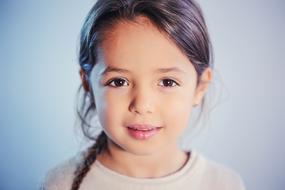 Portrait of a girl in light, at gray and blue background