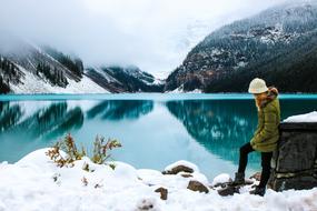 Woman on the beautiful snowy landscape with the lake