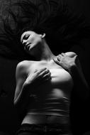 Black and white photo of a woman, posing and touching herself