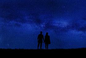 silhouette of a couple in love on the background of a dark blue starry sky