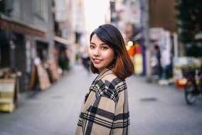 Portrait of the Japanese, smiling girl with make-up, among the street in Tokyo, Japan