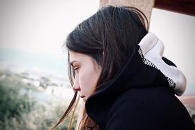 girl in thought in a sweater with a hood