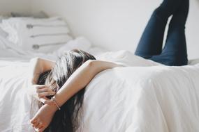 girl lies on the bed with her legs up