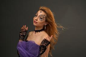 Portrait of the woman, with the colorful make-up, gloves, and hair in the wind