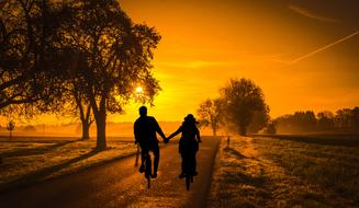 lovers on bicycles in bright yellow twilight