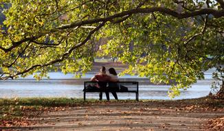 Couple is sitting on the beach near the water on the landscape