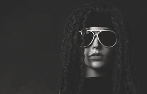 Black and white portrait of the woman with glasses on dark background