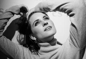 Black and white portrait of the woman holding her hair and looking up