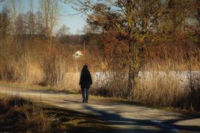 girl walking along the road near the river