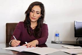 business lady signs a document