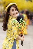 photo of a brunette with a yellow bouquet of flowers