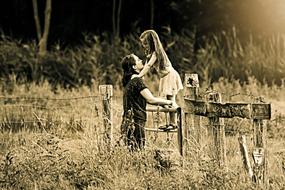 Mother and child at fence on meadow