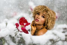 photo of a dark-skinned model and a red flower in the snow