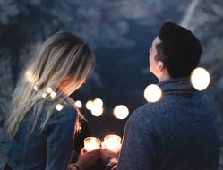 back view of young Man and Woman with candles in hands