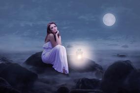 girl in a white dress with a lantern on the seashore against the background of moonlight