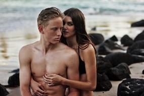 romantic couple in swimsuits on the evening beach